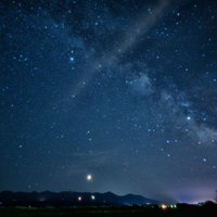 夜空に広がる天の川と田舎道の写真