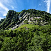 屏風岩の巨大な岩壁と緑の森林、登山道の絶景風景の写真