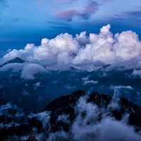 雄大な積雲に包まれる常念山脈の写真