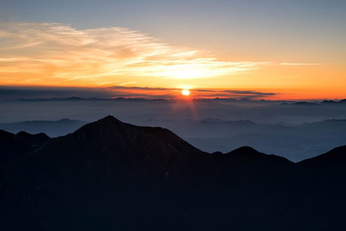 常念岳と日の出の朝焼け、雲海に浮かぶ山々のシルエット
