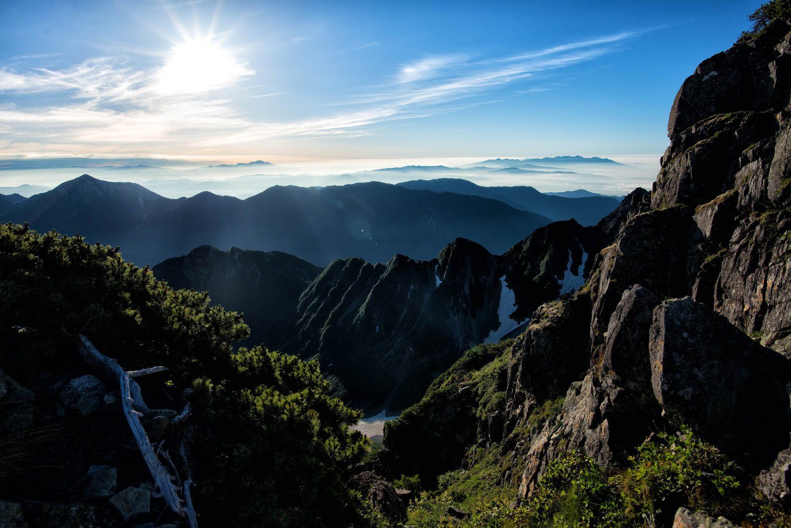 朝日に照らされた穂高の険しい山道と雲海が広がる山岳風景