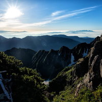 朝日に照らされる穂高の山道と雲海が広がる登山風景の写真