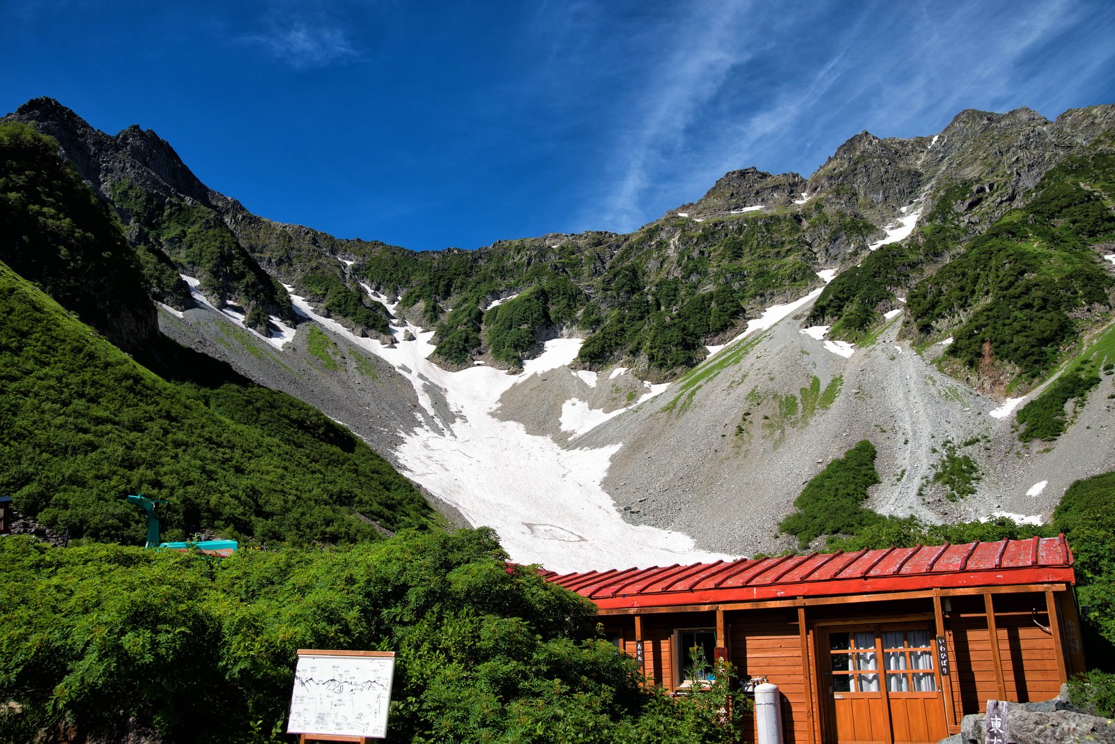 涸沢の診療所いわひばりと背景の雪渓が見える山岳風景