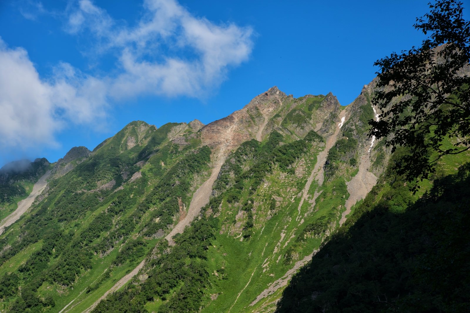 西穂高岳のピラミッドピークと青空に浮かぶ雲の山岳風景