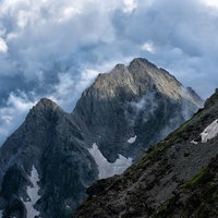 沸き立つ積雲から顔を出す前穂高岳の岩壁と岩稜の写真