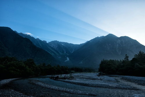 夜明けの上高地を流れる川と山峰、朝焼けに染まる渓谷の風景
