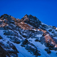 青い空とザイテングラードの雪化粧した岩尾根の写真