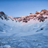モルゲンロートに染まる涸沢の雪山の写真