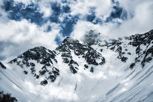 冬の北アルプス・前穂高岳にかかる雲と積雪の山肌