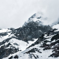 奥穂高岳の雪化粧した山頂と絶壁（北アルプス冬山）の写真