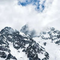 沸き立つ雲に見え隠れする前穂高岳、北アルプスの冬景色の写真