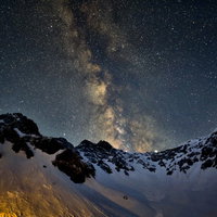 涸沢から立ち上がる天の川と雪山の星空の写真