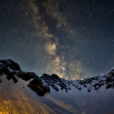 涸沢から立ち上がる天の川と雪山の星空の写真