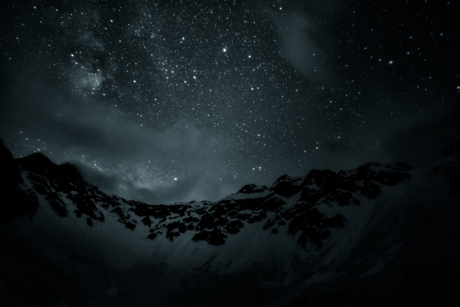 雪に覆われた奥穂高岳の山稜と満天の星空が広がる夜景