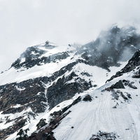 断崖にかかる雲と奥穂高岳の雪山風景（飛騨山脈）の写真