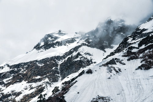 断崖にかかる雲と奥穂高岳の雪山風景（飛騨山脈）