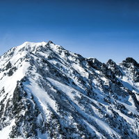 奥穂高岳への道のりと雪に覆われたジャンダルム（飛騨山脈）の写真