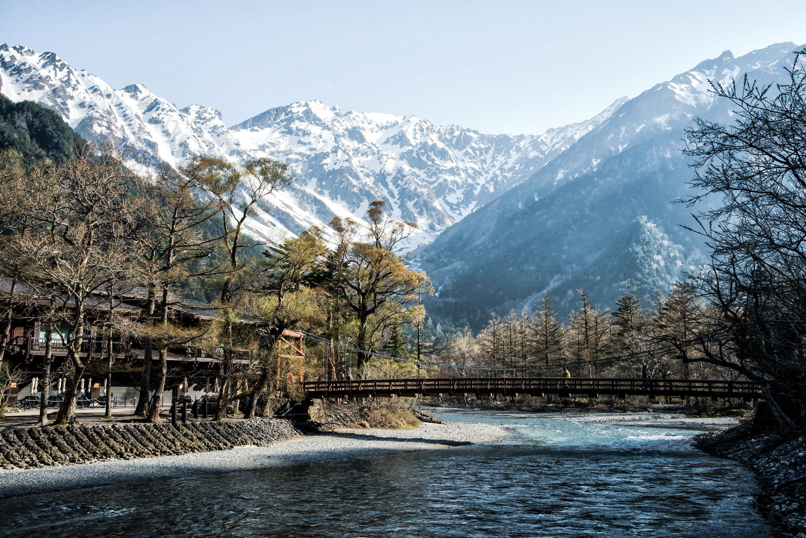 河童橋越しに見える雪化粧した穂高連峰の風景