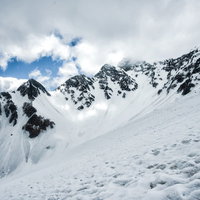 僅かな晴れ間から覗く雪化粧の前穂高岳（飛騨山脈）の写真