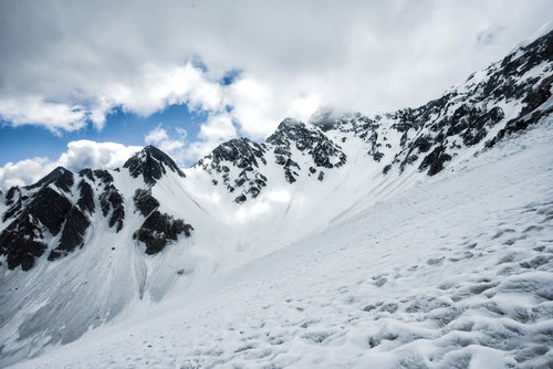 僅かな晴れ間から覗く雪化粧の前穂高岳（飛騨山脈）