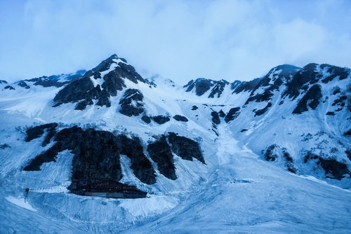 幻想的な夜明け前の涸沢ヒュッテと氷河の雪山