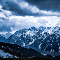 穂高連峰にそそぐ冬の天使のはしご～薄明光線が雪山を照らすの写真