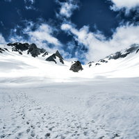 涸沢カールの雪渓に残る登山の足跡と冬山の風景の写真