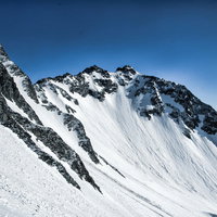残雪期の北穂高岳と雪の転がる跡 冬山の雪景色の写真