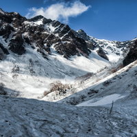 雪解け残雪期の涸沢への道のり、雪渓と岩肌が続く登山道の写真