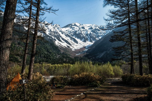 小梨平キャンプ場から見る残雪の雪山と春の新緑