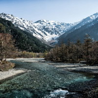 残雪の上高地から流れ行く梓川と焼岳の雄大な山風景の写真