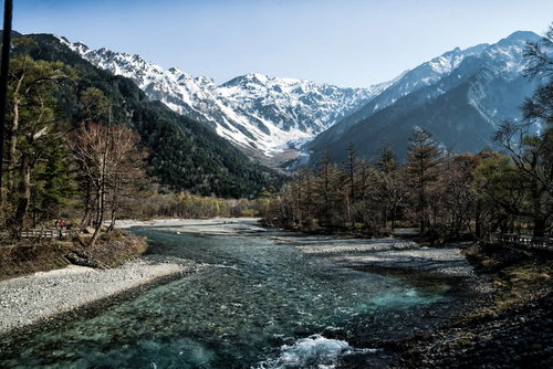 残雪の上高地から流れ行く梓川と焼岳の雄大な山風景
