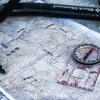 雪山登山の装備、地図とコンパスとピッケルの写真