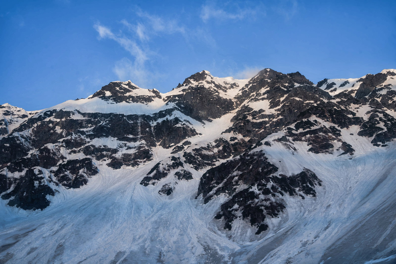 青空の下に雪化粧した奥穂高岳の山岳風景