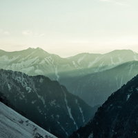 朝日が差し込む常念山脈の雪山風景の写真