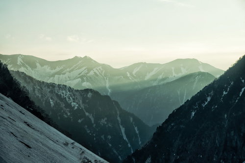 朝日が差し込む常念山脈の雪山風景