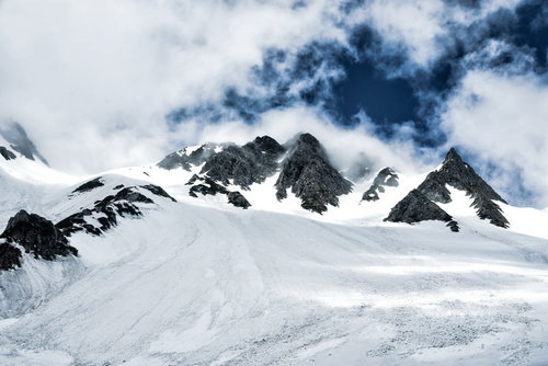 低い雲に覆われた雪の涸沢岳、北アルプスの冬山風景