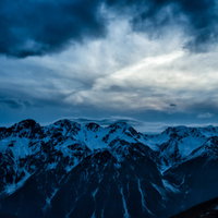 飛騨山脈にかかる傘雲と雪化粧した山々の冬景色の写真