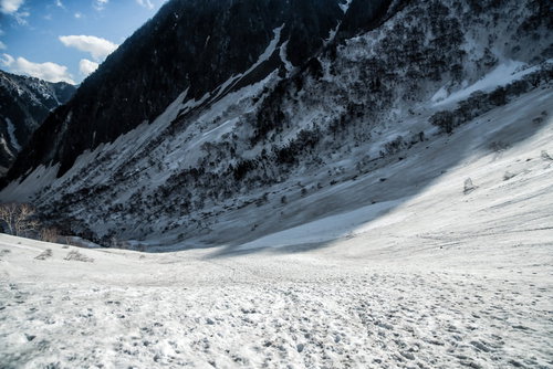 涸沢から横尾へルートにかかる影、雪に覆われた冬山の下り道