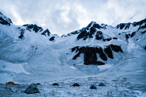 涸沢のテント場と山小屋が雪に覆われた光景
