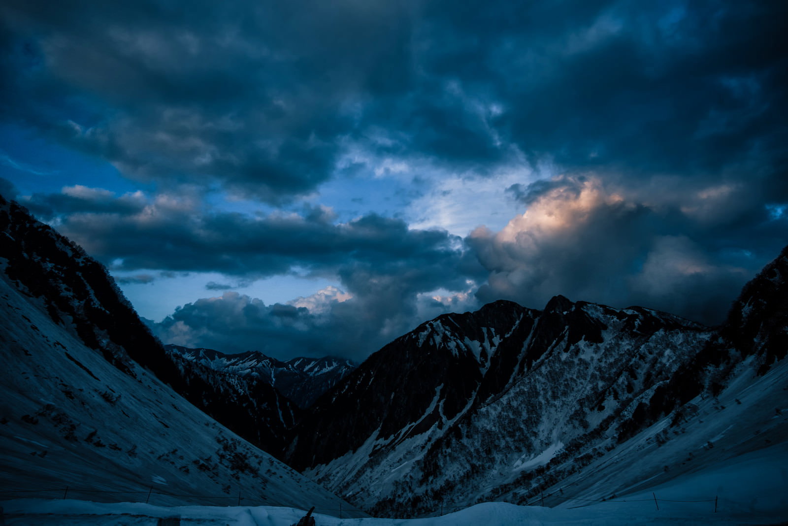 残雪期の涸沢から見た常念山脈方面の夕暮れの雪山風景