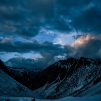 残雪期の涸沢から望む常念山脈の夕暮れと登山者の写真