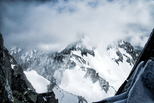 涸沢岳から望む雲がかかる北穂高岳の雪景色（北アルプス）