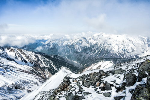 雪に覆われた北アルプス・涸沢岳頂上から眺める笠ヶ岳