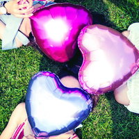 ハートバルーンを持った三人組女子の夏の友情の写真