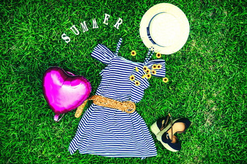 夏服おでかけセット、芝生に並べたボーダーワンピースと麦わら帽子