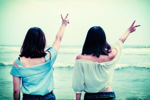 海辺で後ろ姿でピースする記念撮影 - 青春の思い出