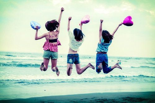 砂浜でジャンプする元気な女性たちの夏の思い出