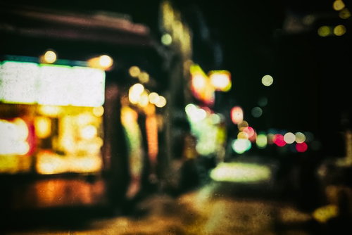 深夜営業のお店の看板をボケで捉えた夜間の街並み