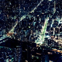 ビル群の夜景と川を行き交う屋形船の写真